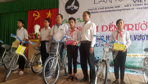 Đại diện Ban quản trị Hội Bảo tồn lan rừng Việt Nam trao tặng xe và tập cho các em học sinh